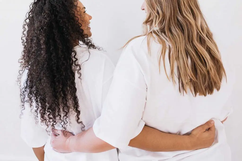 Two girls with their hands around each others backs