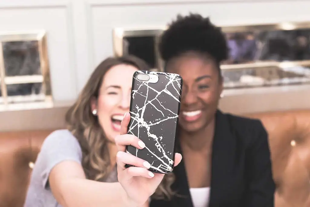 Two friends laughing and taking a selfie