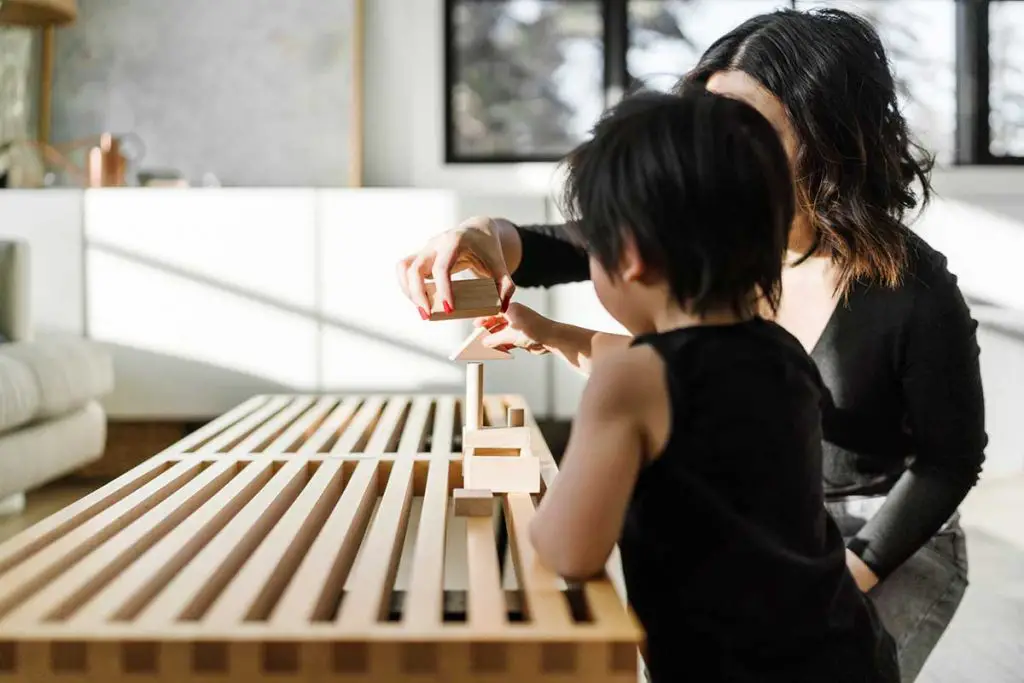 Woman with child playing with blocks