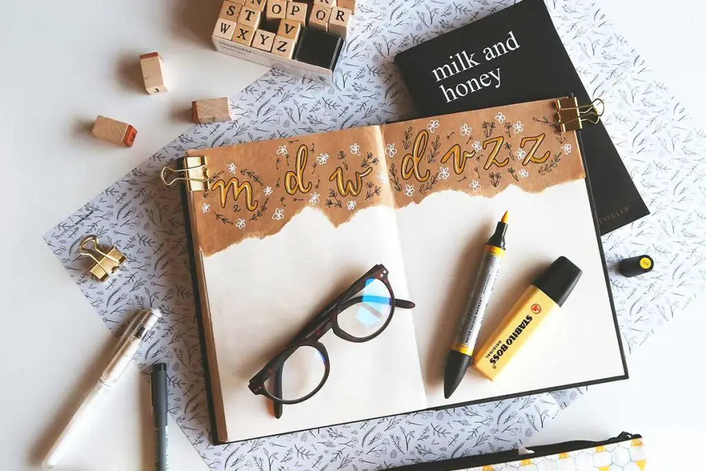 Journal surrounded by supplies and book