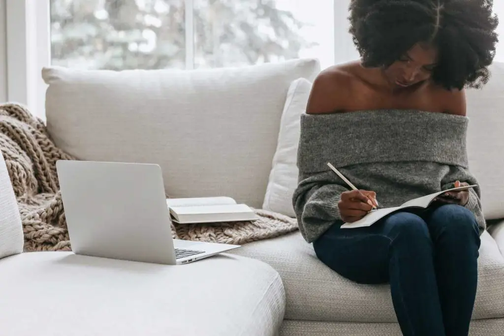 Woman writing in gratitude journal