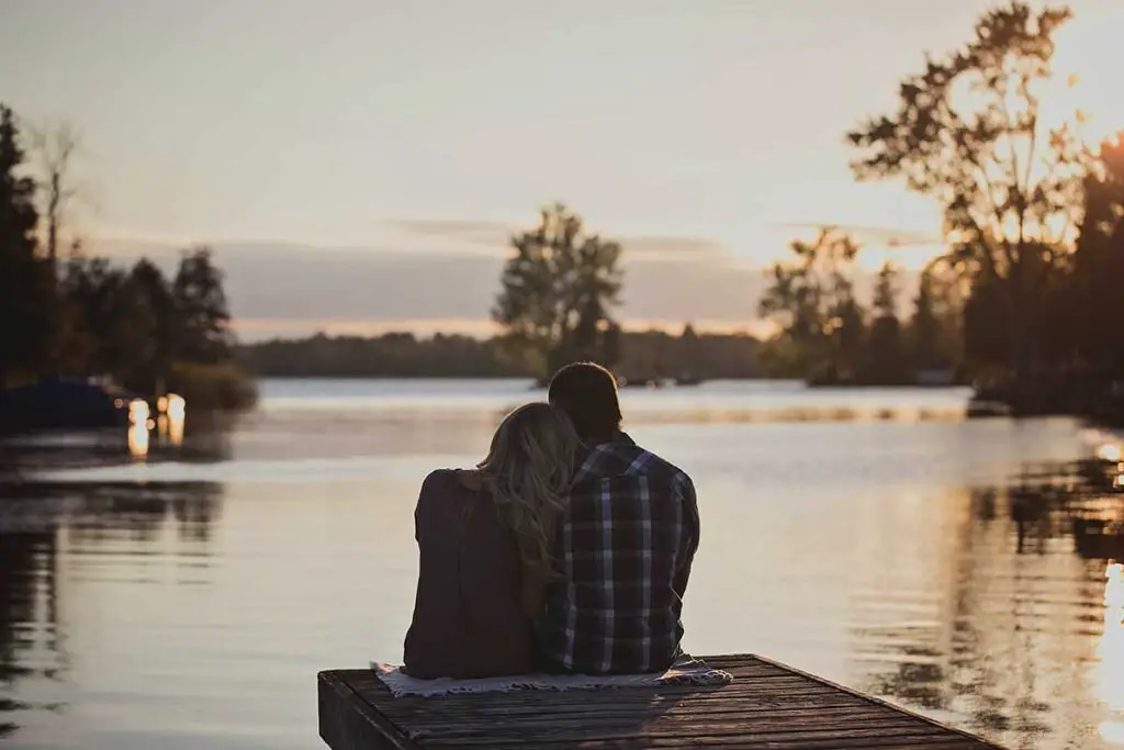 Couple staring out at lake water together