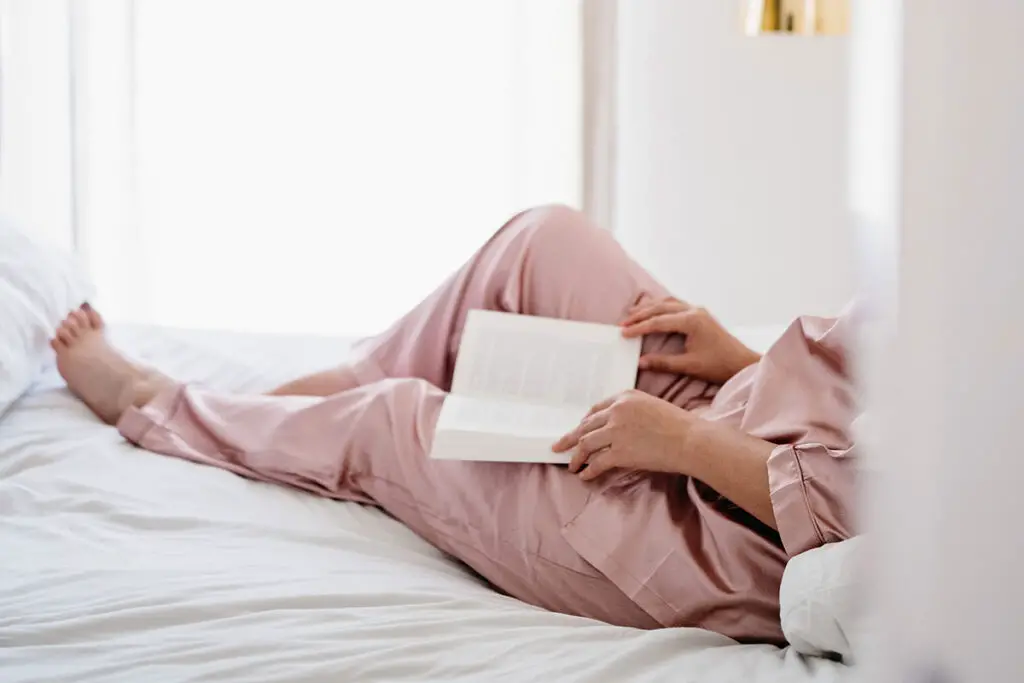 Woman reading book in bed