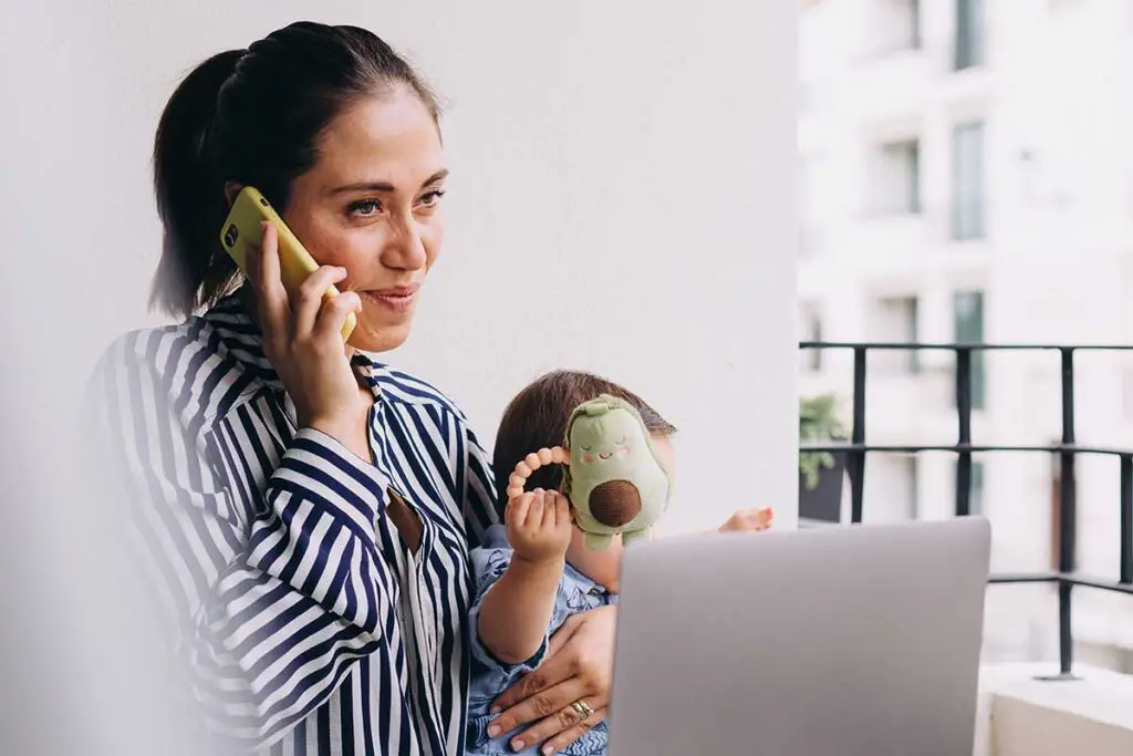 Woman on phone with child next to her