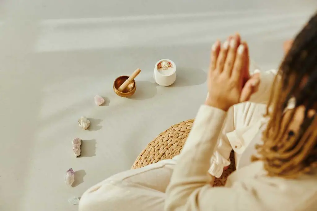 Woman meditating on floor with crystals