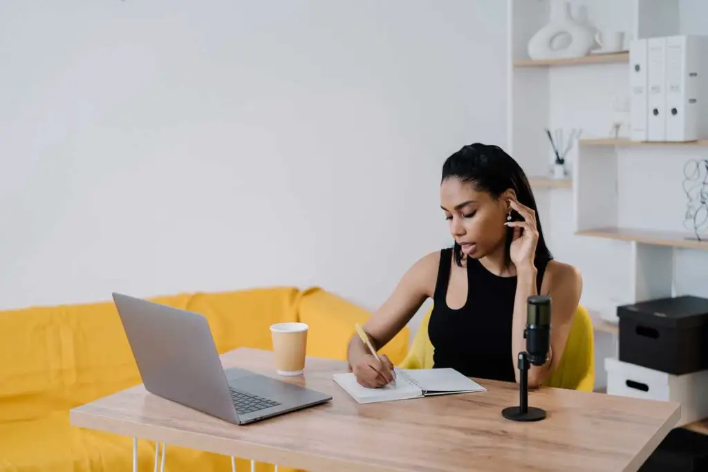 Woman writing in front of computer