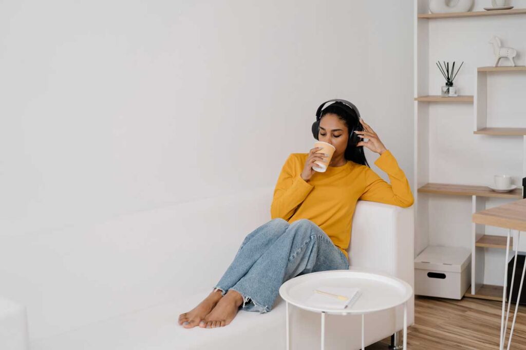 Woman drinking coffee and listening to headphones